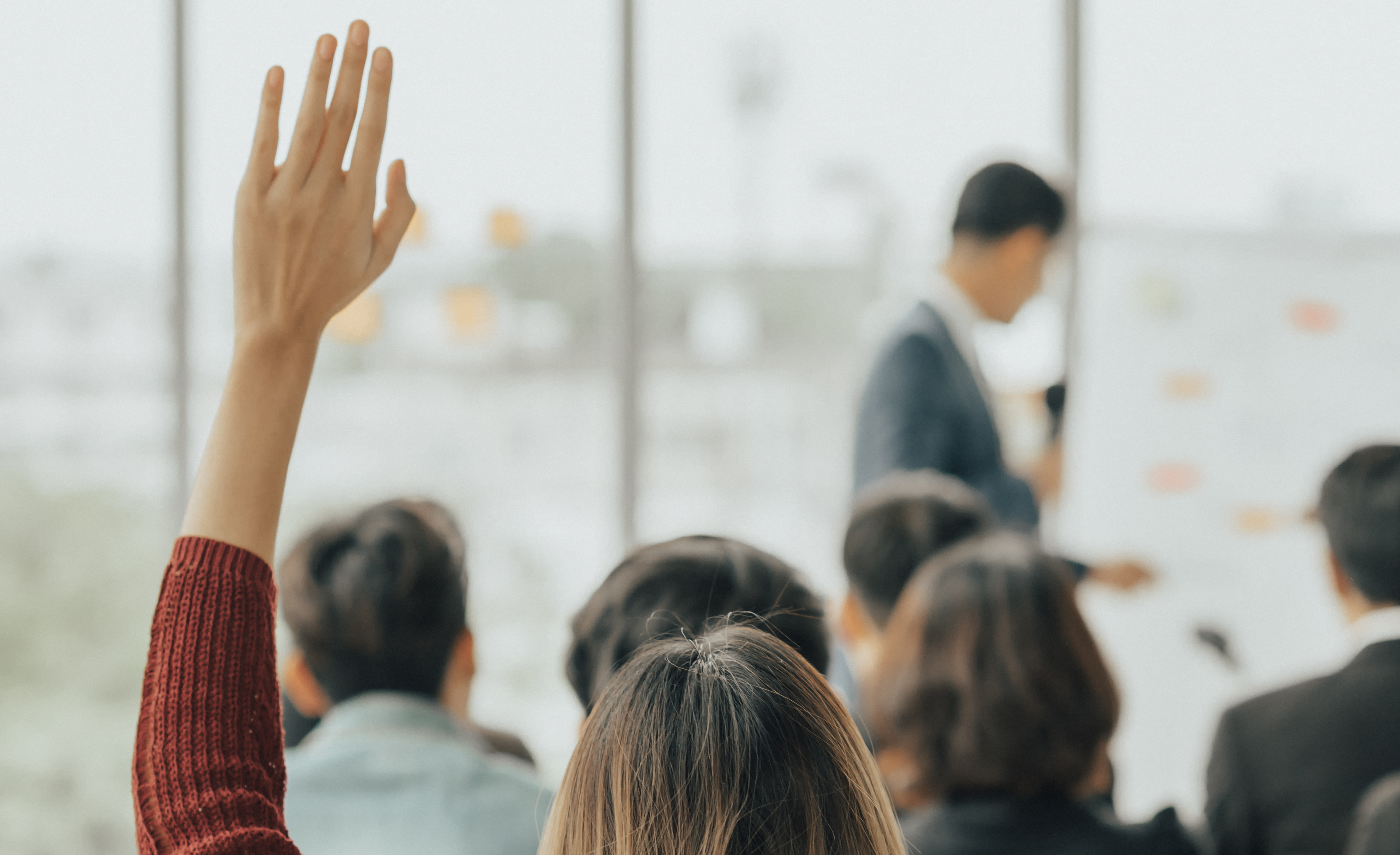 A hand raised to ask a question A hand raised to ask a question