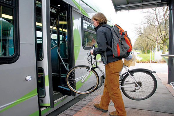 person entering the back of an EmX bus with a bike