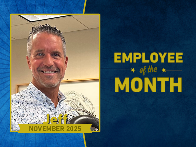 A man smiles holding a circular award. Text reads: 