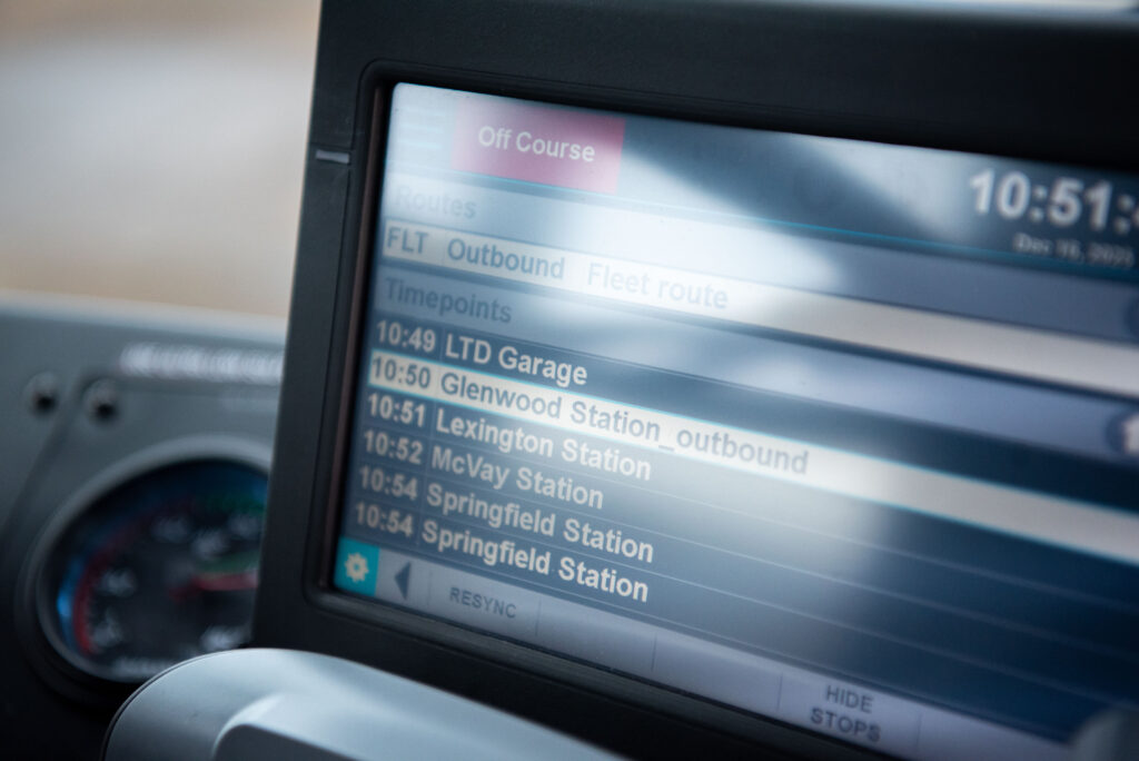 A digital display shows outbound bus routes and departure times, listing stops such as LTD Garage, Glenwood Station, and Springfield Station.