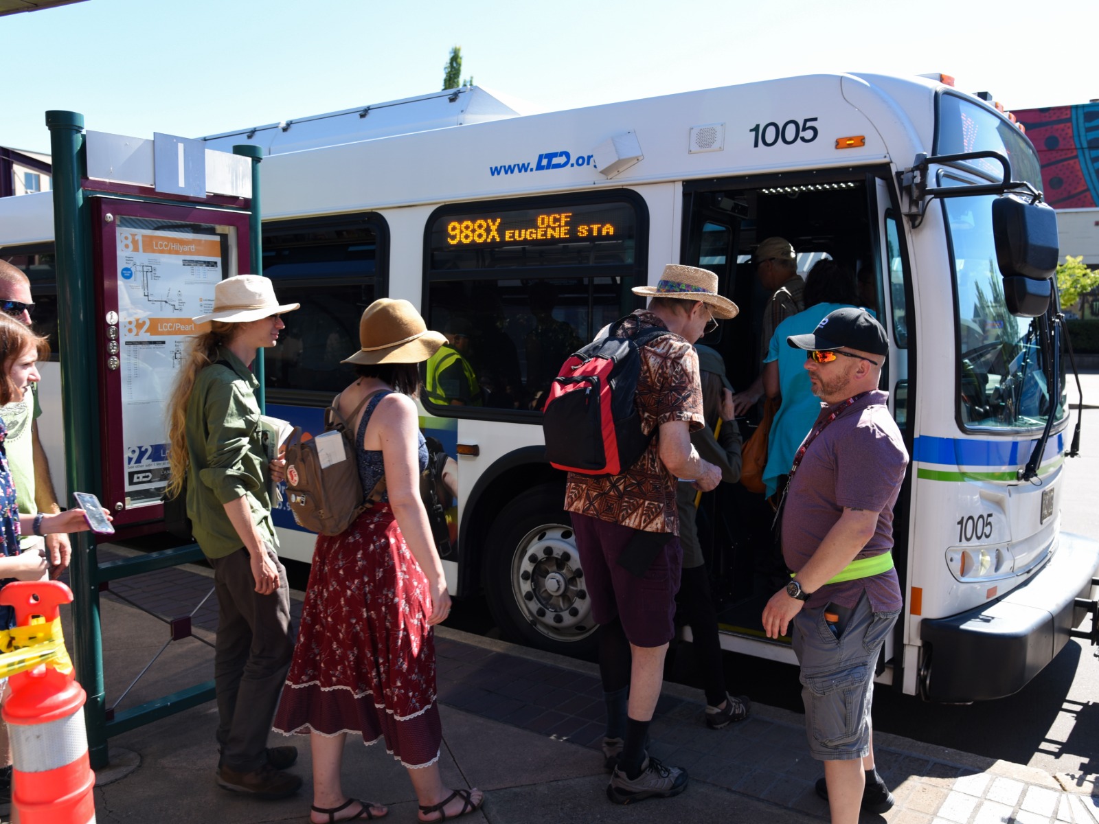 A group of people board a city bus labeled 
